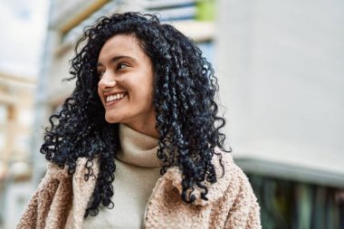 Sokakta kendinden emin gülümseyen genç İspanyol kadın.