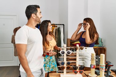 Bir grup İspanyol gülümseyen insan elbise mağazasında gözlük denerken mutlu olurlar..