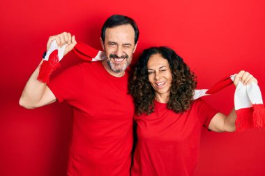 Orta yaşlı İspanyol bir çift ve eşarp takan bir adam futbol takımı holiganları tezahürat yapıyor. Kameraya seksi bir ifadeyle bakıyor, neşeli ve mutlu bir yüzle.. 