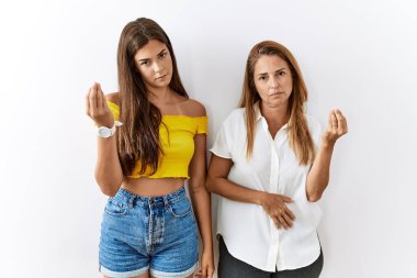 Anne ve kızı birlikte izole edilmiş bir arka planda el ve parmakları ile italyan jestleri yaparak bir arada duruyorlar. 