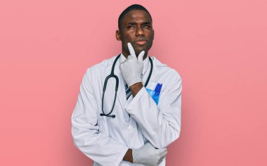 Doktor üniforması giyen ve steteskop takmış genç Afro-Amerikan bir adam. Ciddi bir yüz ifadesi var. Çene ve çeneyle ilgili sorular soruyor. 