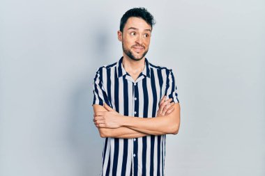 Gündelik kıyafetler giyen genç İspanyol adam gülümseyip yan tarafa bakıyor ve düşünüyor.. 