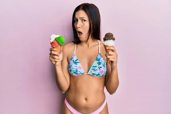 Genç Latin Kadın Bikini Giyip Elinde Dondurmayla Şaşkın Şaşkın Şüpheci — Stok fotoğraf