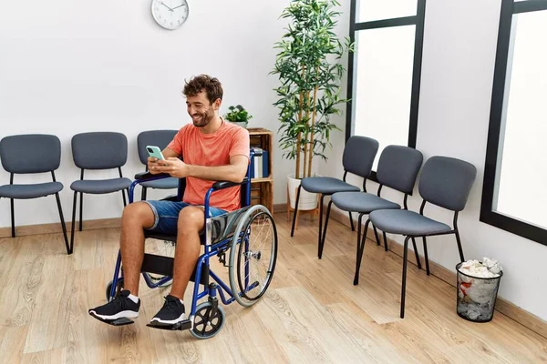 Jovem Hispânico Usando Smartphone Sentado Cadeira Rodas Sala Espera Clínica — Fotografia de Stock