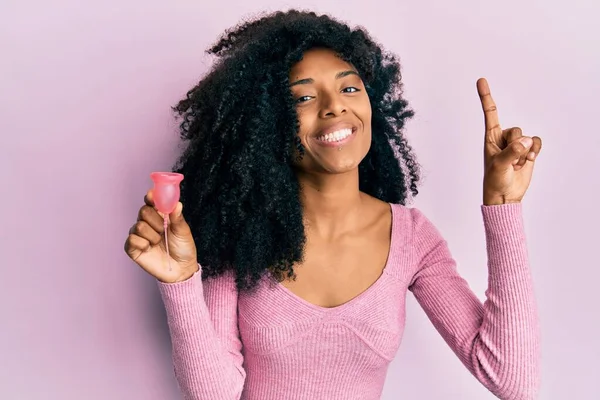 Африканская Американка Афроволосами Держащая Менструальную Чашку Удивлена Идеей Вопросом Указывая — стоковое фото