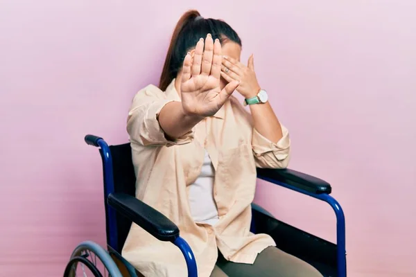 Ung Latinamerikansk Kvinna Sitter Rullstol Och Täcker Ögonen Med Händer — Stockfoto
