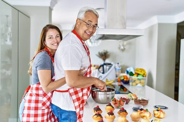 Casal Hispânico Meia Idade Sorrindo Feliz Abraçando Doces Cozinha Cozinha — Fotografia de Stock