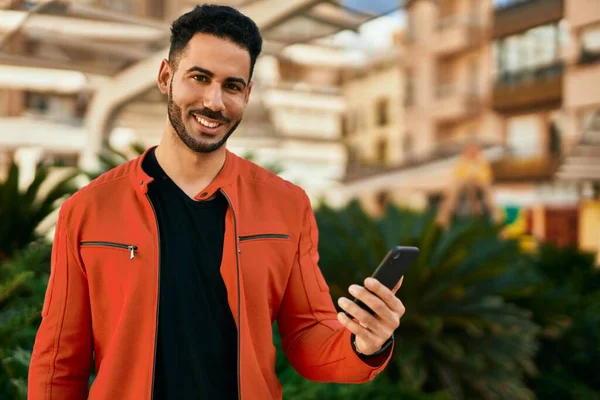 Ung Latinamerikansk Man Ler Glad Med Smartphone Stan — Stockfoto