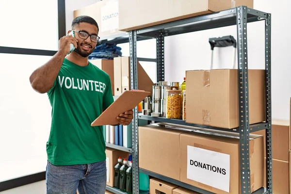 Jonge Arabier Man Draagt Vrijwilliger Uniform Praten Smartphone Het Liefdadigheidscentrum — Stockfoto