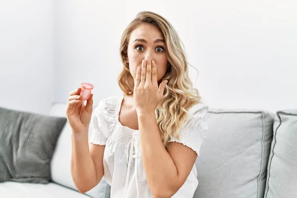 Blonde Young Woman Holding Menstrual Cup Covering Mouth Hand Shocked — Stock Photo, Image