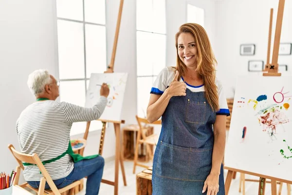 Hispanic Woman Wearing Apron Art Studio Doing Happy Thumbs Gesture — Foto Stock