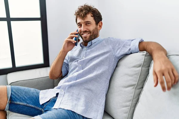 Joven Hombre Hispano Hablando Teléfono Inteligente Sentado Sofá Casa —  Fotos de Stock