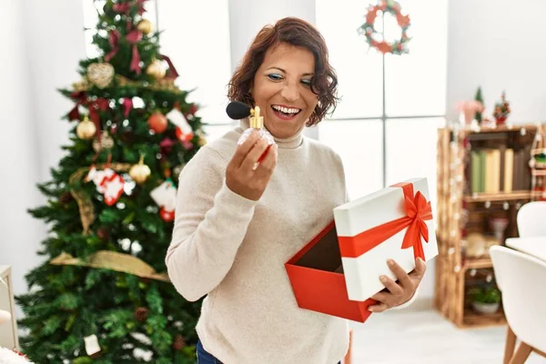 Middelbare Leeftijd Spaanse Vrouw Houden Geschenk Stand Door Kerstboom Thuis — Stockfoto