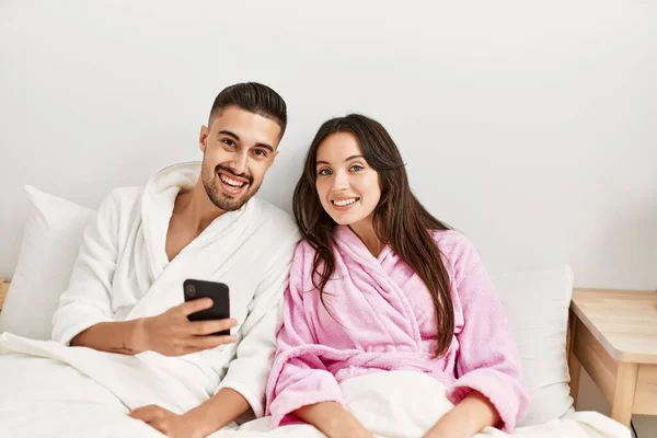 Genç Spanyol Çift Evde Yatarken Akıllı Telefon Kullanıyor — Stok fotoğraf