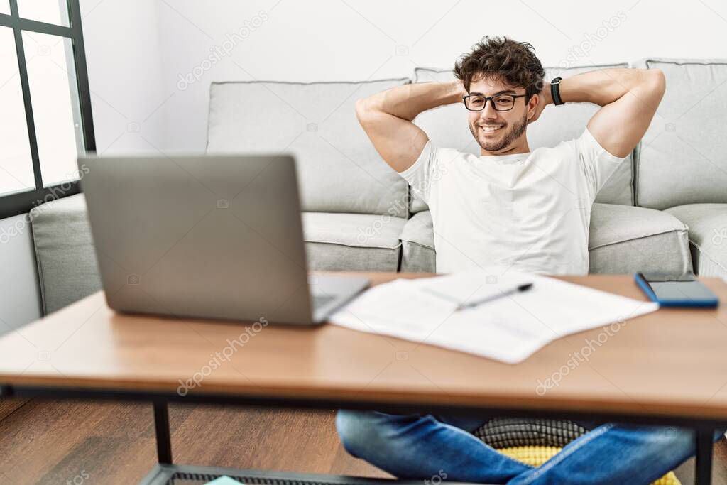 Young hispanic man smiling confident studying at home