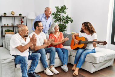 Bir grup orta yaşlı arkadaş evdeki kanepede oturup klasik gitar çalıyorlar..