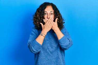 Gündelik kıyafetler giyen orta yaşlı İspanyol kadın yanlışlıkla elleri ile ağzını kapatırken şok oldu. gizli kavram. 