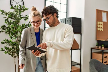 Ofiste dizüstü bilgisayarla çalışırken gülümseyen iki iş adamı.