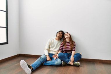 Genç İspanyol çift tavana bakıyor. Boş bir evde yerde oturuyorlar..