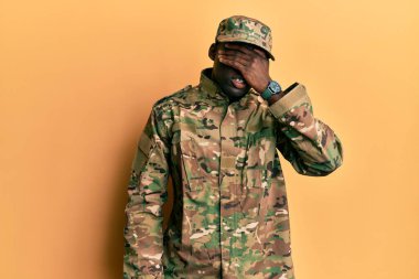 Asker üniforması giymiş genç Afro-Amerikan bir adam. Gülümsüyor ve elleri yüzünde gülüyor. Şaşırtmak için gözleri örtüyor. kör kavram. 