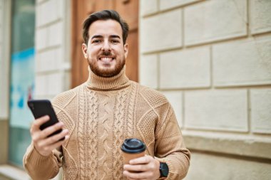 Kafkasyalı genç adam akıllı telefon kullanıyor. Şehirde kahve içiyor..