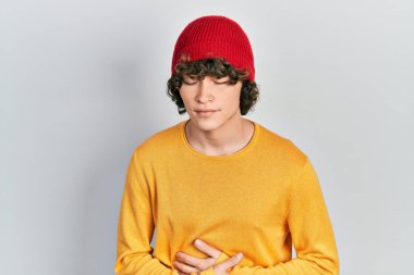 Midenin üstüne yün şapka takan yakışıklı genç bir adam. Çünkü hazımsızlık, acı verici bir hastalık ve kendini iyi hissetmiyor. Ağrı kavramı. 