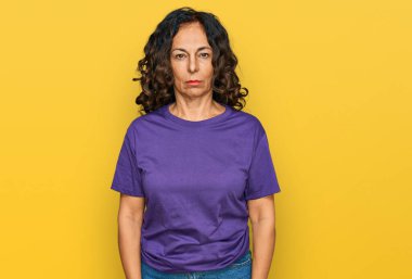 Orta yaşlı İspanyol kadın, günlük giysiler giyiyor, depresyonda ve endişe içinde, kızgın ve korkmuş bir şekilde ağlıyor. hüzünlü ifade. 