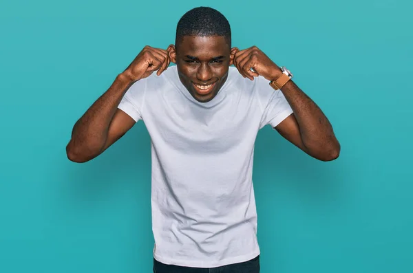 Joven Hombre Afroamericano Vistiendo Camiseta Blanca Casual Sonriendo Tirando Las —  Fotos de Stock