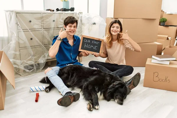 Young Caucasian Couple Dog Holding Our First Home Blackboard New — стоковое фото