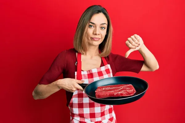 Νεαρή Καυκάσιος Ξανθιά Γυναίκα Φορώντας Ποδιά Μάγειρας Μαγείρεμα Κρέας Στο — Φωτογραφία Αρχείου