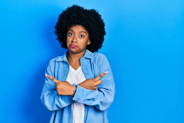 若いアフリカ系アメリカ人の女性は 指で両側を指してカジュアルな服を着て 異なる方向は反対 — ストック写真