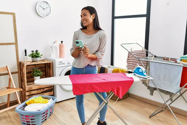 Ung Latinamerikansk Kvinna Använder Smartphone Strykning Tvättstuga — Stockfoto