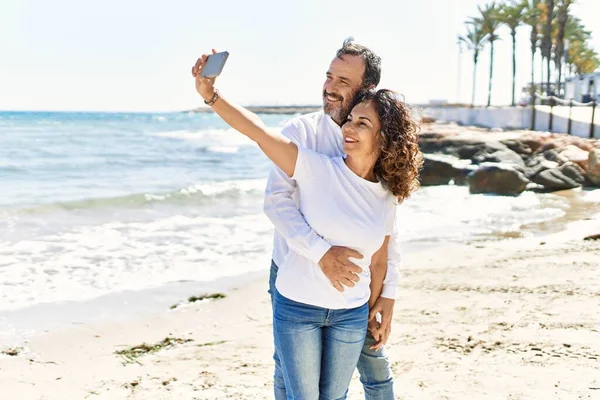 Orta Yaşlı Spanyol Çift Mutlu Gülümsüyor Sahilde Telefon Başında Selfie — Stok fotoğraf