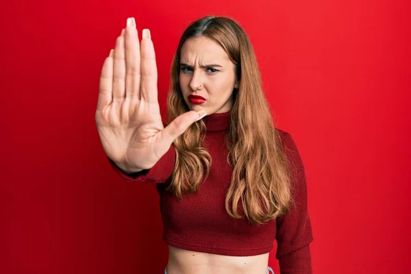 터틀넥 스웨터를 금발의 여자가 손바닥으로 노래부르는 멈추었다 부정적 표정으로 경고의 — 스톡 사진