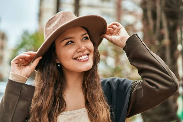 Joven Turista Hispana Sonriendo Feliz Sosteniendo Sombrero Ciudad —  Fotos de Stock