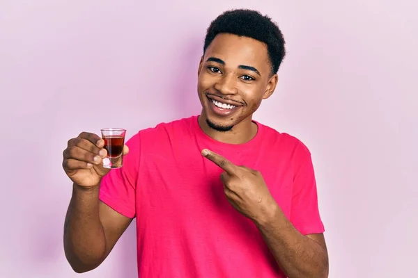 Joven Afroamericano Bebiendo Whisky Tiro Sonriente Feliz Señalando Con Mano — Foto de Stock