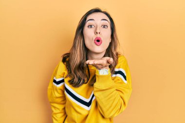 Gündelik giysiler giymiş genç İspanyol kız kameraya bakıyor. Canlı yayında öpüşüyorlar. Güzel ve seksiler. aşk ifadesi. 