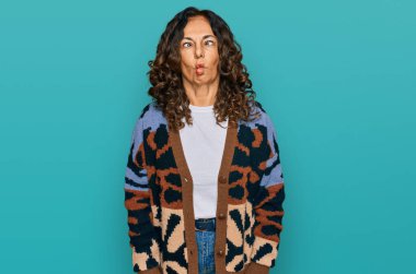 Orta yaşlı İspanyol kadın gündelik kıyafetler giyip dudaklarıyla balık suratı yapıyor, çılgınca ve komik hareketler yapıyor. Komik ifade. 