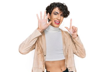 Handsome man wearing make up and woman clothes showing and pointing up with fingers number seven while smiling confident and happy. 