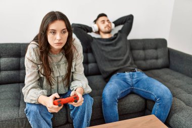 Genç İspanyol çift video oyunu oynuyor ve evde müzik dinliyor..