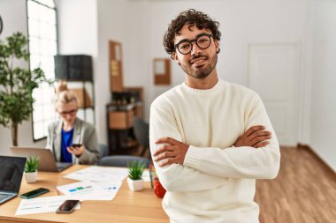 İş adamı kollarını kavuşturup mutlu bir şekilde gülümsüyor..