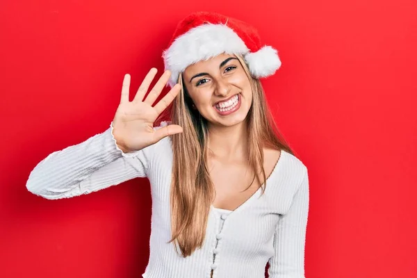 美しいですヒスパニック女性身に着けていますクリスマスの帽子ショーと指摘指番号5ながら笑顔自信と幸せ — ストック写真