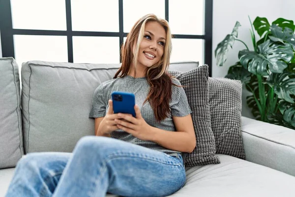 Beyaz Kız Akıllı Telefon Kullanıyor Evdeki Kanepede Oturuyor — Stok fotoğraf