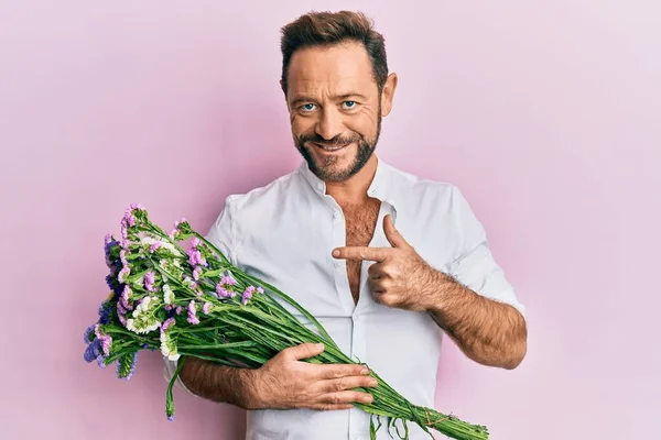 Homem Meia Idade Segurando Flores Sorrindo Feliz Apontando Com Mão — Fotografia de Stock