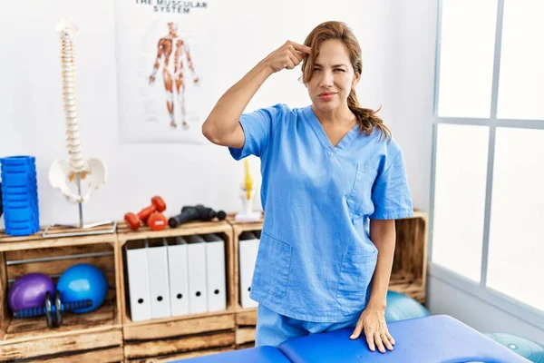 Hispánská Fyzioterapeutka Středního Věku Pracující Klinice Pro Zotavení Bolesti Ukazující — Stock fotografie