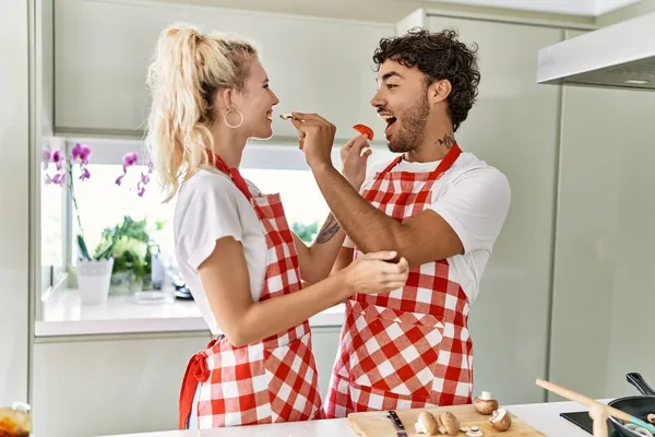Pareja Joven Sonriendo Feliz Cocinando Pizza Italiana Dándose Comida Uno — Foto de Stock