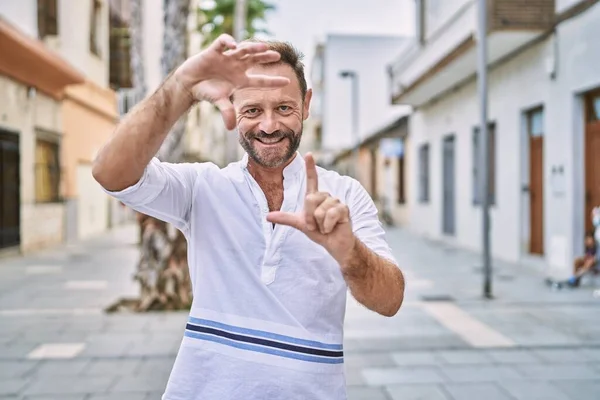Hombre Mediana Edad Aire Libre Ciudad Sonriendo Haciendo Marco Con —  Fotos de Stock
