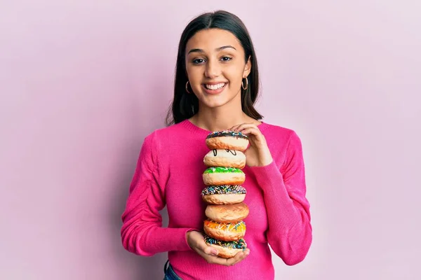 Mulher Hispânica Jovem Segurando Pilha Saborosos Donuts Coloridos Sorrindo Com — Fotografia de Stock