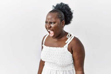 Genç Afrikalı bir kadın, izole edilmiş beyaz bir arka planda öfkeli ve kızgın bir şekilde bağırıyor öfkeyle bağırıyor. öfke ve agresif konsept. 