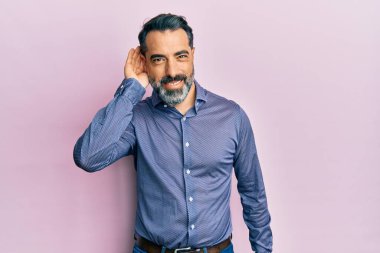 Orta yaşlı, sakallı, iş kıyafetleri giyen, ağzı kulaklarında gülümseyen dedikoduları ve dedikoduları dinleyen bir adam. Sağırlık kavramı. 